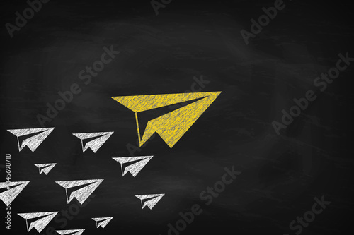Leadership concept, Big and Yellow paper plane leading white paper planes on black chalkboard