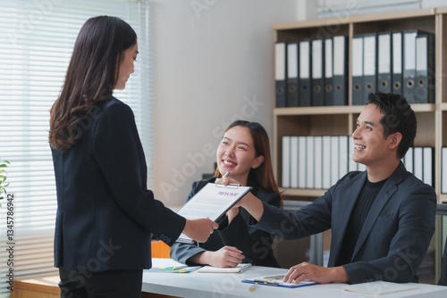 Applicant giving resume to hr managers in office for job interview