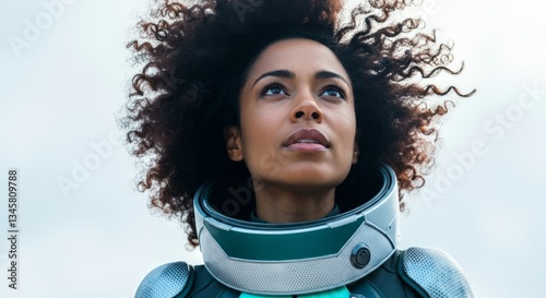Young african female astronaut gazing upward in spacesuit