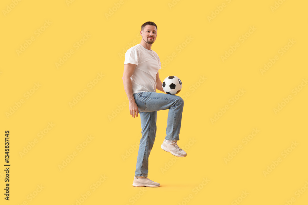 Fototapeta premium Man playing with soccer ball on yellow background