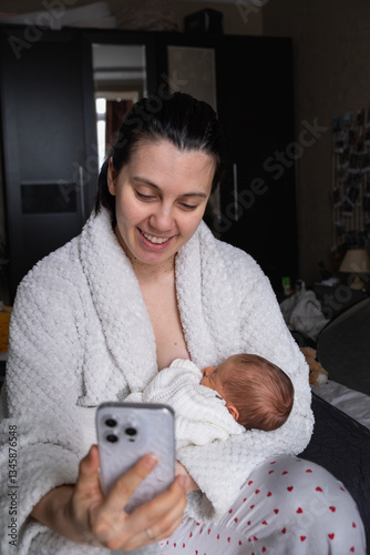 Obraz na płótnie Mother Smiling at Smartphone with Newborn Baby w salonie