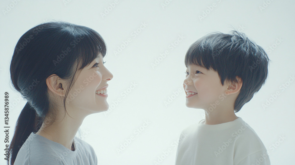 Studio Portrait of a Happy Asian Mother and Daughter: A Family Concept Featuring a Japanese Young Mother and Cute Son Interacting and Smiling in Front of a Plain White Background Studio Portrait of a Happy Asian Mother and Daughter: A Family Concept Featuring a Japanese Young Mother and Cute Son Interacting and Smiling in Front of a Plain White Background