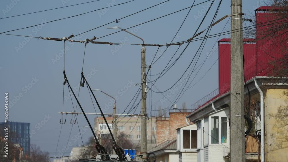 Trolleybus passes bend of wire, turns at intersection, stops at the public transport stop, passengers get on the bus and leave. Electric wires on which the trolleybus travels in the city. Trolleybus passes bend of wire, turns at intersection, stops at the public transport stop, passengers get on the bus and leave. Electric wires on which the trolleybus travels in the city.