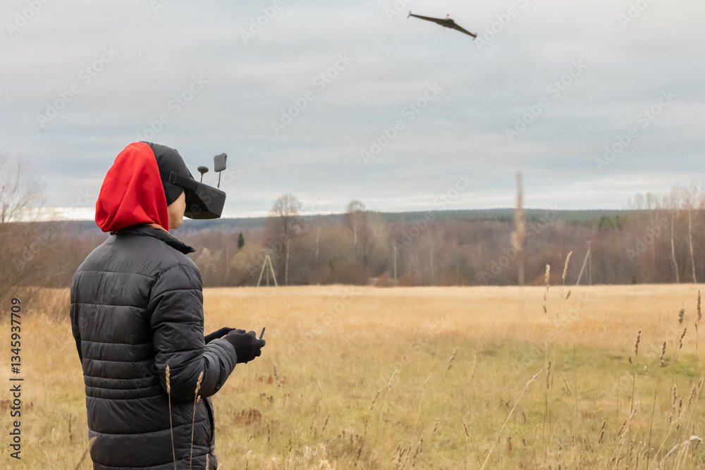 Young man launches rc plane into sky. Teenager with glasses playing with toy radio-controlled airplane outdoors. Boy holding radio remote controller. Young man launches rc plane into sky. Teenager with glasses playing with toy radio-controlled airplane outdoors. Boy holding radio remote controller.