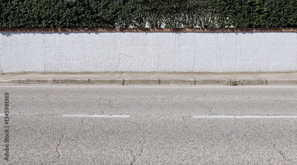 Φωτογραφία House fence made of white stucco with row of bricks and a hedge on top
