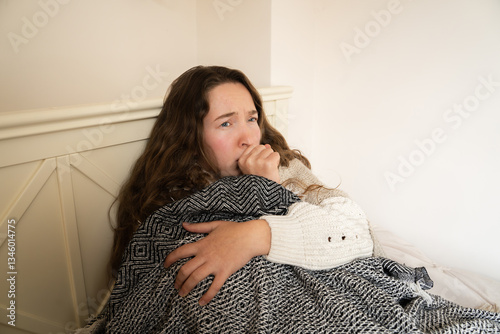 Foto Sick tired young woman coughing, lying in bed under a warm blanket, feeling weak unwell, looking exhausted