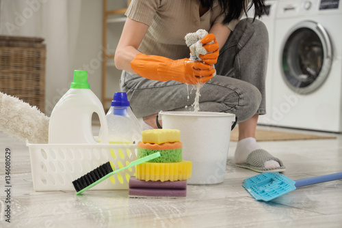 Woman wringing mop in laundry room, closeup