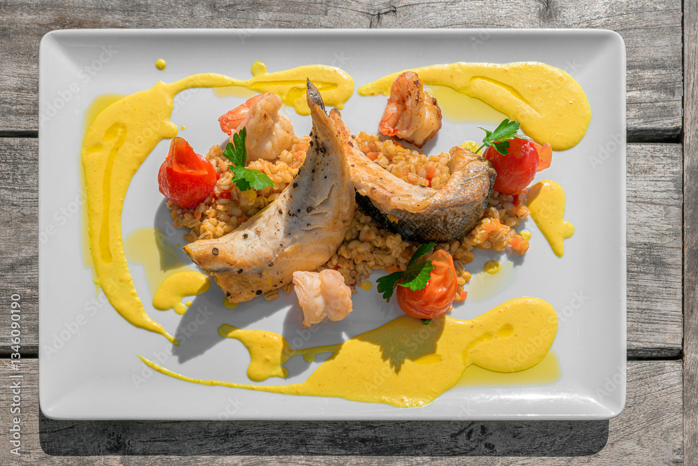 fried sea bass fillet and prawns on vegetable and pearl barley risotto and a tempting lemon-ginger sauce