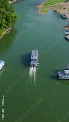 Vertical drone shot following a Lijiang river cruise ferry in Yangshou, China