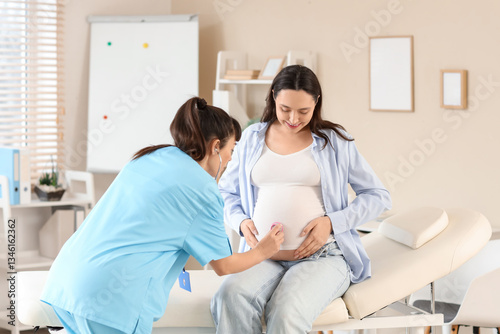 Female doctor with stethoscope listening to pregnant woman's belly in clinic
