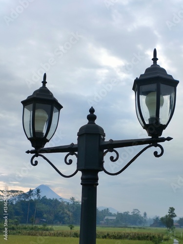Classic lamppost with two lanterns silhouetted against a soft, overcast sky