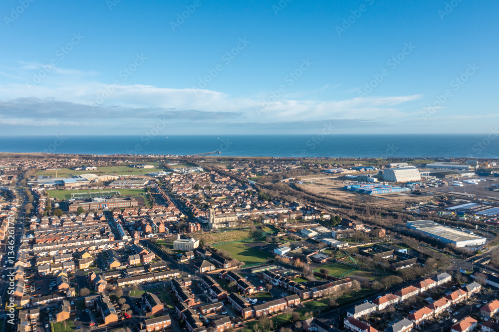 Aerial drone photo of the town of Hartlepool in the UK showing rows of terrace houses and homes and typical British suburban housing estates with the ocean in the background in the winter time