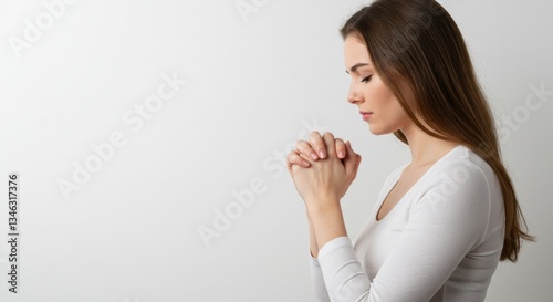 Woman praying with hands clasped.
