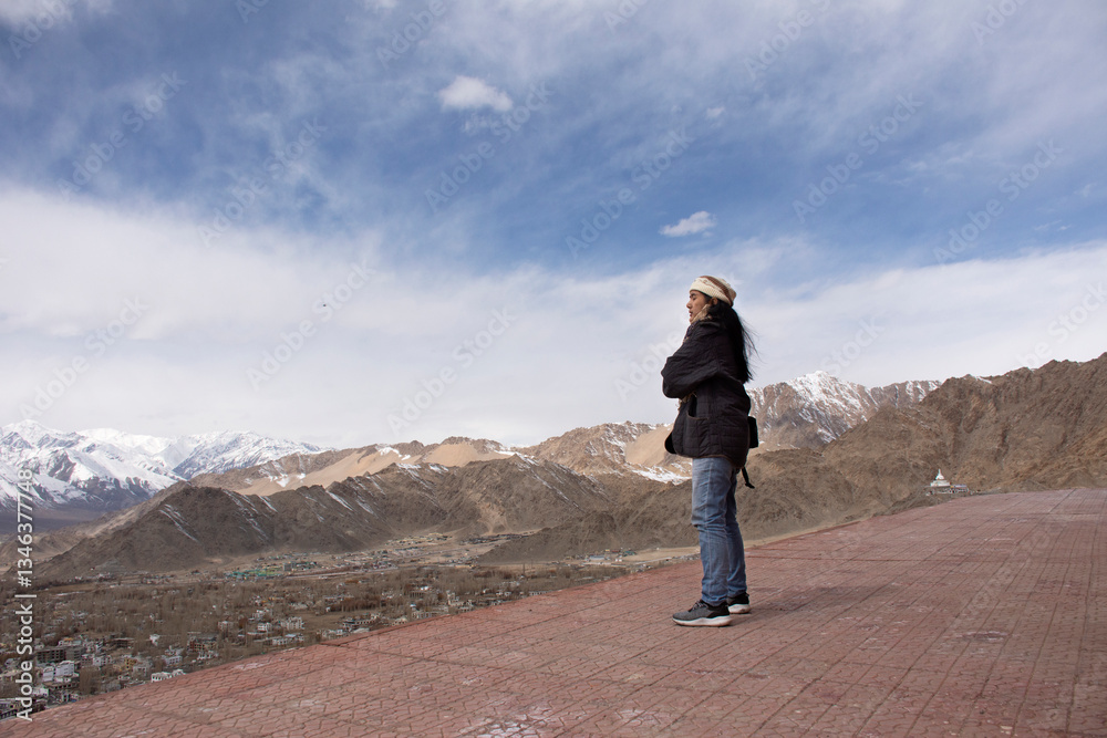 Obraz premium Travelers thai women people travel visit and posing with view landscape of Leh Ladakh Village from viewpoint of Thiksey monastery and Namgyal Tsemo Gompa in Jammu and Kashmir, India in winter season