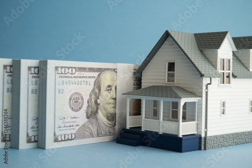 House and US dollar banknotes on blue background. Financial planning for home buying, mortgage loan, home equity loan, home for cash, banking, real estate property and so on concept.
