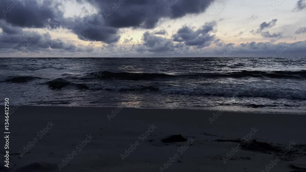 A tranquil beach view featuring gentle waves rolling in at dusk, set beneath a dramatic, cloudadorned sky A tranquil beach view featuring gentle waves rolling in at dusk, set beneath a dramatic, cloudadorned sky