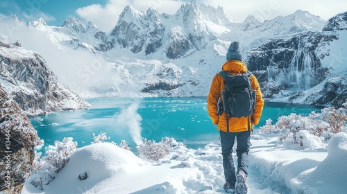 Adventurer in snowy mountains by a turquoise lake