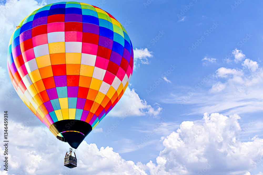 Fototapeta premium Colorful hot air balloon flying over blue sky with white clouds