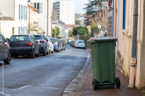 Plastic container for waste collection on the street. Bin for garbage outdoors on with lid. Trash like domestic refuse, rubbish, recycling and garden waste, France, Paris photo