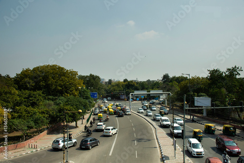 Indian people and foreigners drive car and ride motorcycle and bike bicycle and walk on street with traffic road at New Delhi city in New Delhi, India