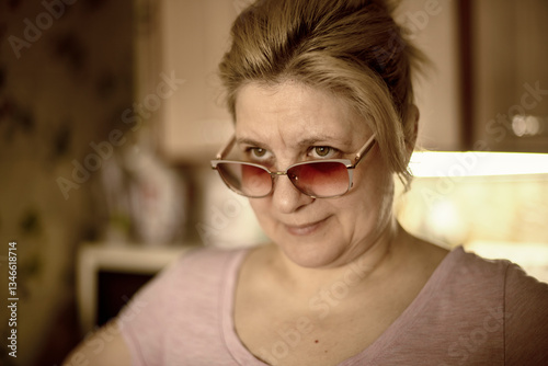 A woman wearing sunglasses and a pink shirt