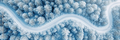Aerial view of a winding road in a winter forest with snow-covered trees