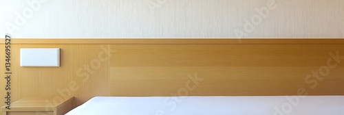 Simple, light-colored hotel bedroom with wooden headboard