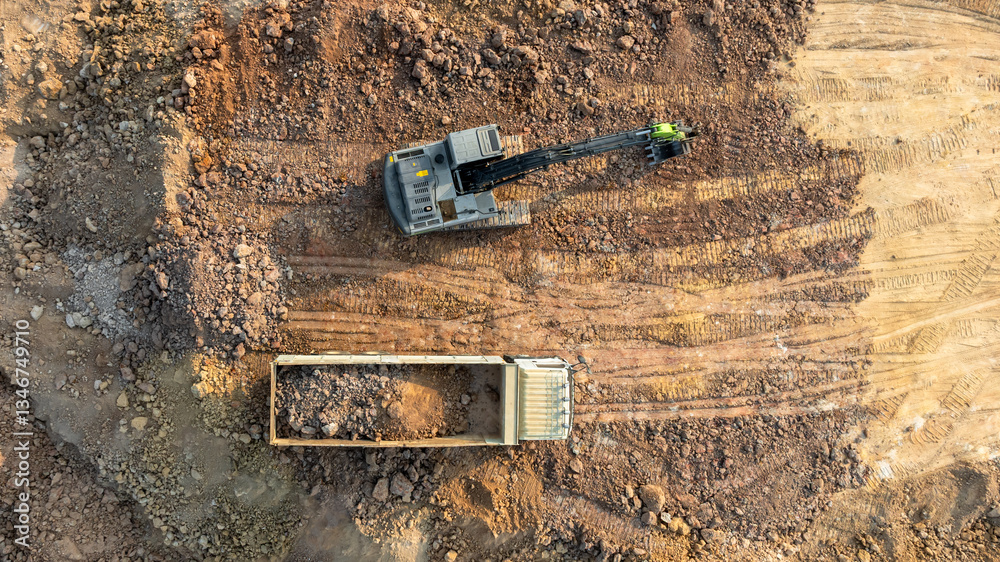 Excavator digs move earth at construction site, Excavator working and digging at construction site, Crawler excavator digger earth gravel on transportation truck at construction site, Top view..