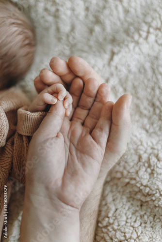 Parents holding newborn baby hand close up. Love and family concept. Happy Fathers day! Happy Mothers day. Dad and mom bonding with sweet little infant. Adoption. Child health and care