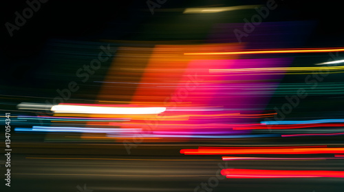 Vibrant streaks of light illustrating speed and motion on a nighttime highway.