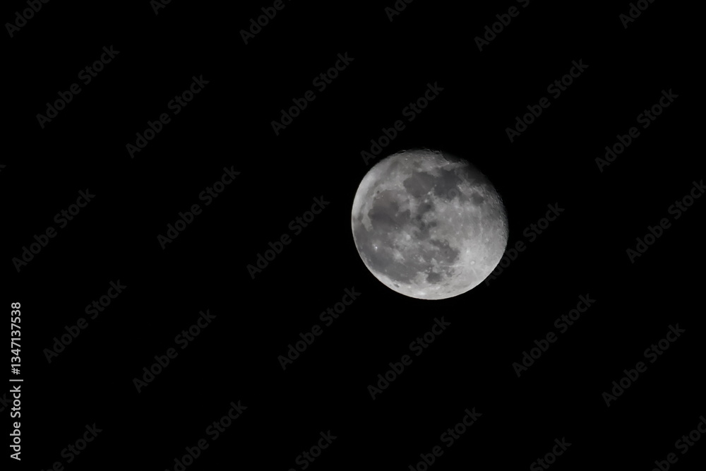 A natural view of the moon partially covered by soft clouds in the night sky. A serene and atmospheric scene capturing the beauty of the celestial landscape A natural view of the moon partially covered by soft clouds in the night sky. A serene and atmospheric scene capturing the beauty of the celestial landscape