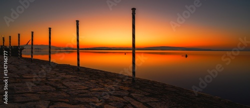 Red dawn on the pier of Arona on Lake Maggiore in Italy.