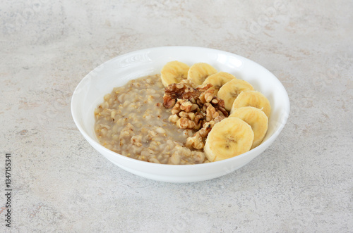 A delicious bowl of oatmeal with banana slices and walnuts
