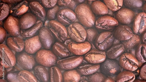 Coffee background. Close-up of whole roasted coffee beans with smoke rising and dissipating. 