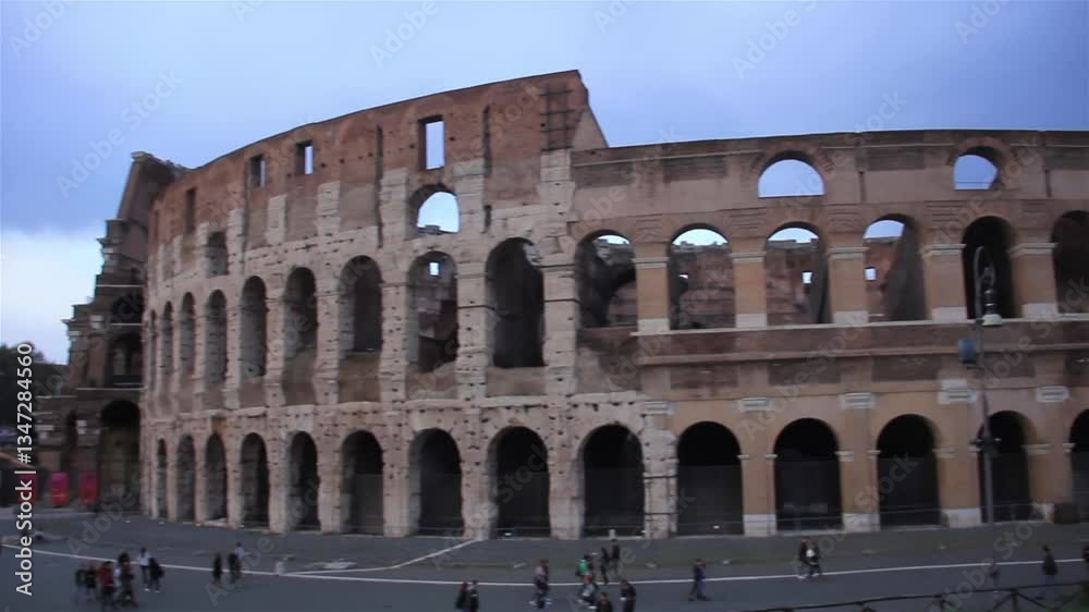 Tourists and Locals Walking by the Colosseum at Dusk Tourists and Locals Walking by the Colosseum at Dusk