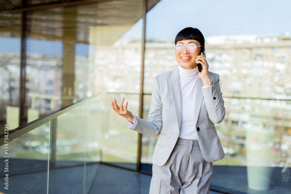 Confident Japanese businesswoman engaging in a lively conversation in a modern corporate setting Confident Japanese businesswoman engaging in a lively conversation in a modern corporate setting