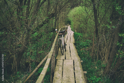 vintage bike on the old wooden bridge over small forest river.spring mood