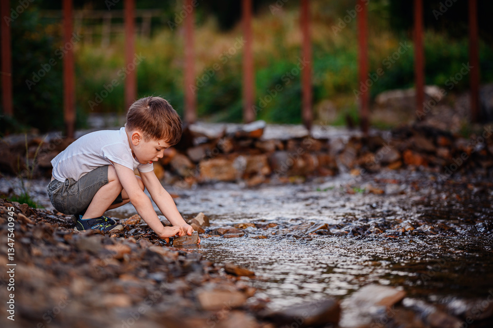Young Boy Playing by a Rocky Stream in Nature Young Boy Playing by a Rocky Stream in Nature
