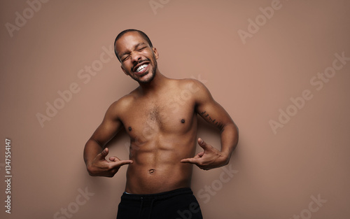 Muscular handsome man with perfect body, posing shirtless over white wall. Isolated.