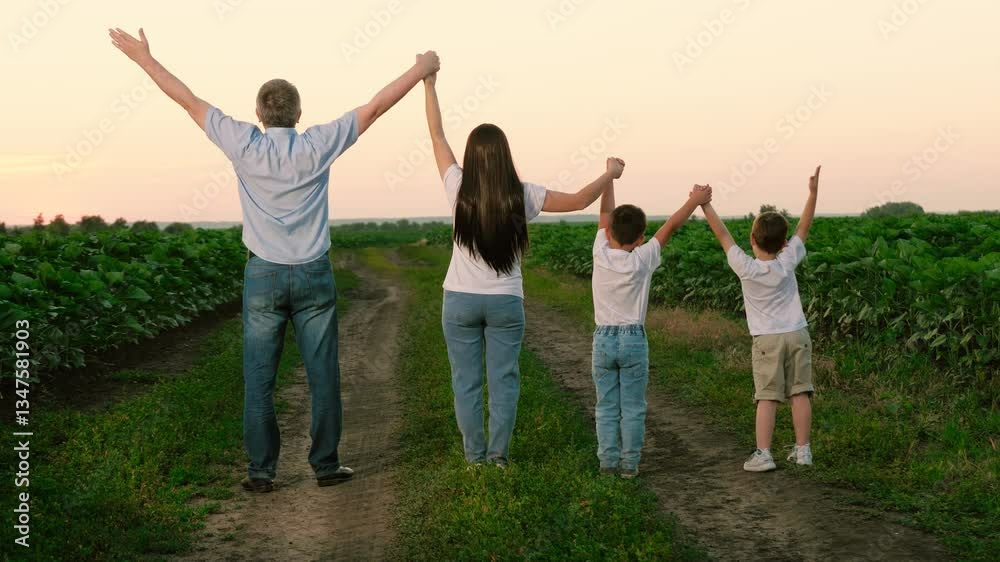 Joyful family with kids raises hands standing in meadow during summer break. Delighted family and kids relish being together in natural park on vocation. Children with family raise hands in unison Joyful family with kids raises hands standing in meadow during summer break. Delighted family and kids relish being together in natural park on vocation. Children with family raise hands in unison