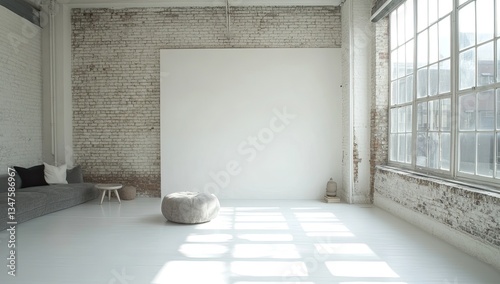Empty loft studio with large blank wall, sunlight streams in