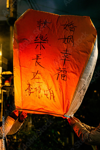 Brightly lit Chinese floating lantern with messages being released