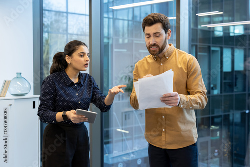 Fényképezés A man and woman are having a heated discussion in their office space