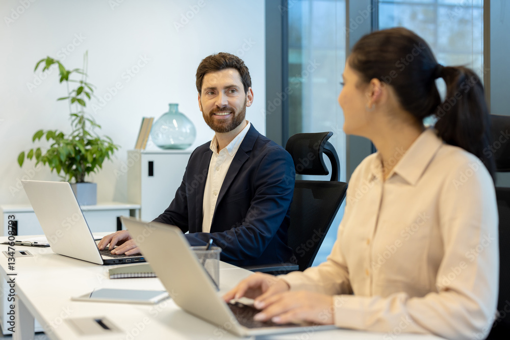 Obraz premium Two colleagues are collaborating in the office, working together on their laptops and sharing ideas.