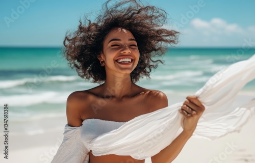 The concept of people and leisure is embodied by a happy woman wearing a shawl and waving in the wind on a summer beach