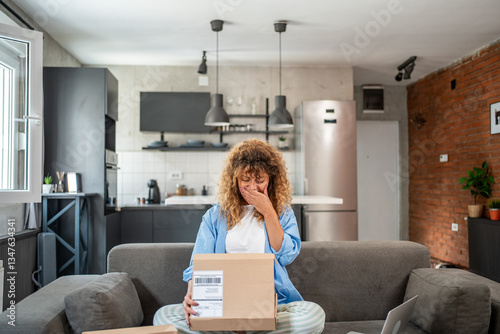 Woman is crying while unboxing a package at home