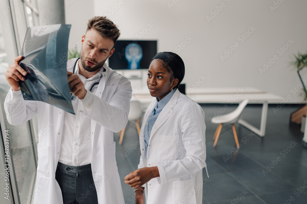 Fototapeta premium Doctors examining x ray of patient in modern hospital