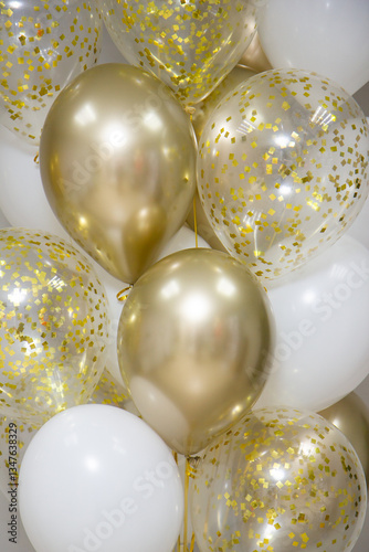 bouquet of gold, white and clear balloons with confetti