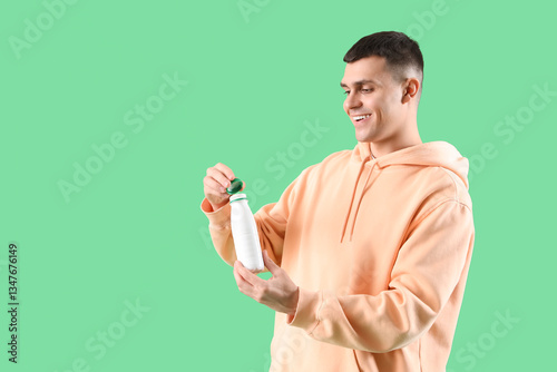 Young man with bottle of ta...