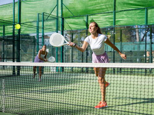 Wallpaper Mural Padel game - woman with partners plays on the tennis court Torontodigital.ca